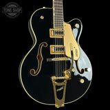 Black and gold electric guitar with 'Tone Shop' logo in the corner