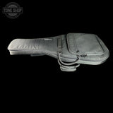 A gray padded guitar or bass instrument bag shown from the side against a black background, with a front zip pocket and a small Tone Shop watermark in the upper left corner.