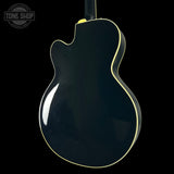 Glossy black electric guitar body with a visible brand logo in the corner.