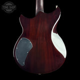 The back of an electric guitar with a glossy dark reddish-brown wood finish, featuring a silver pickguard and a white side cutout, shown against a black background.