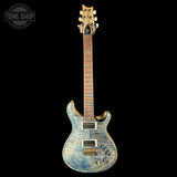 Electric guitar with a blue and brown finish on a black background, featuring the Tone Shop logo.