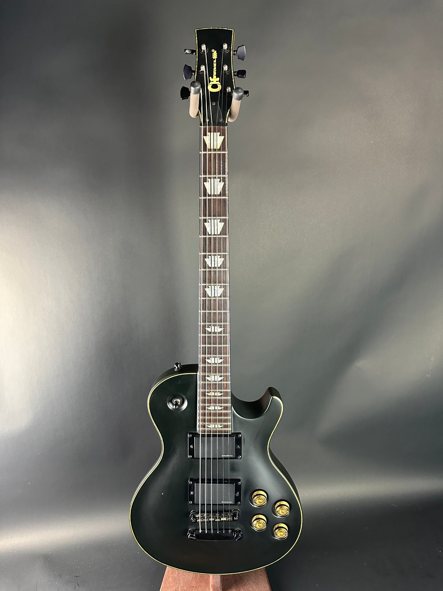 Black electric guitar on a gray background