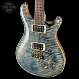 Electric guitar with a blue and brown finish on a black background, featuring the Tone Shop logo.