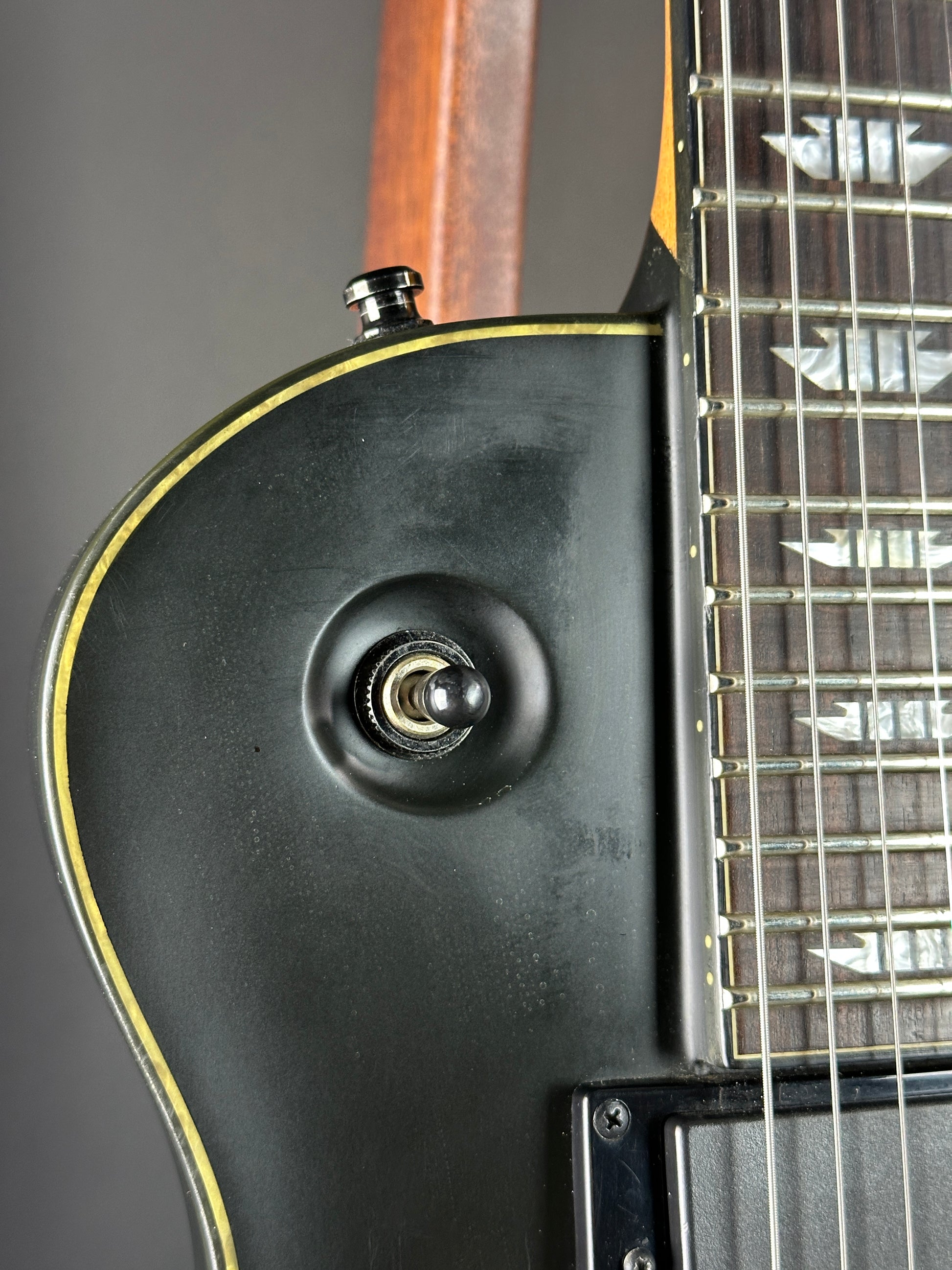 Close-up of an electric guitar's body with a focus on the pickup and neck
