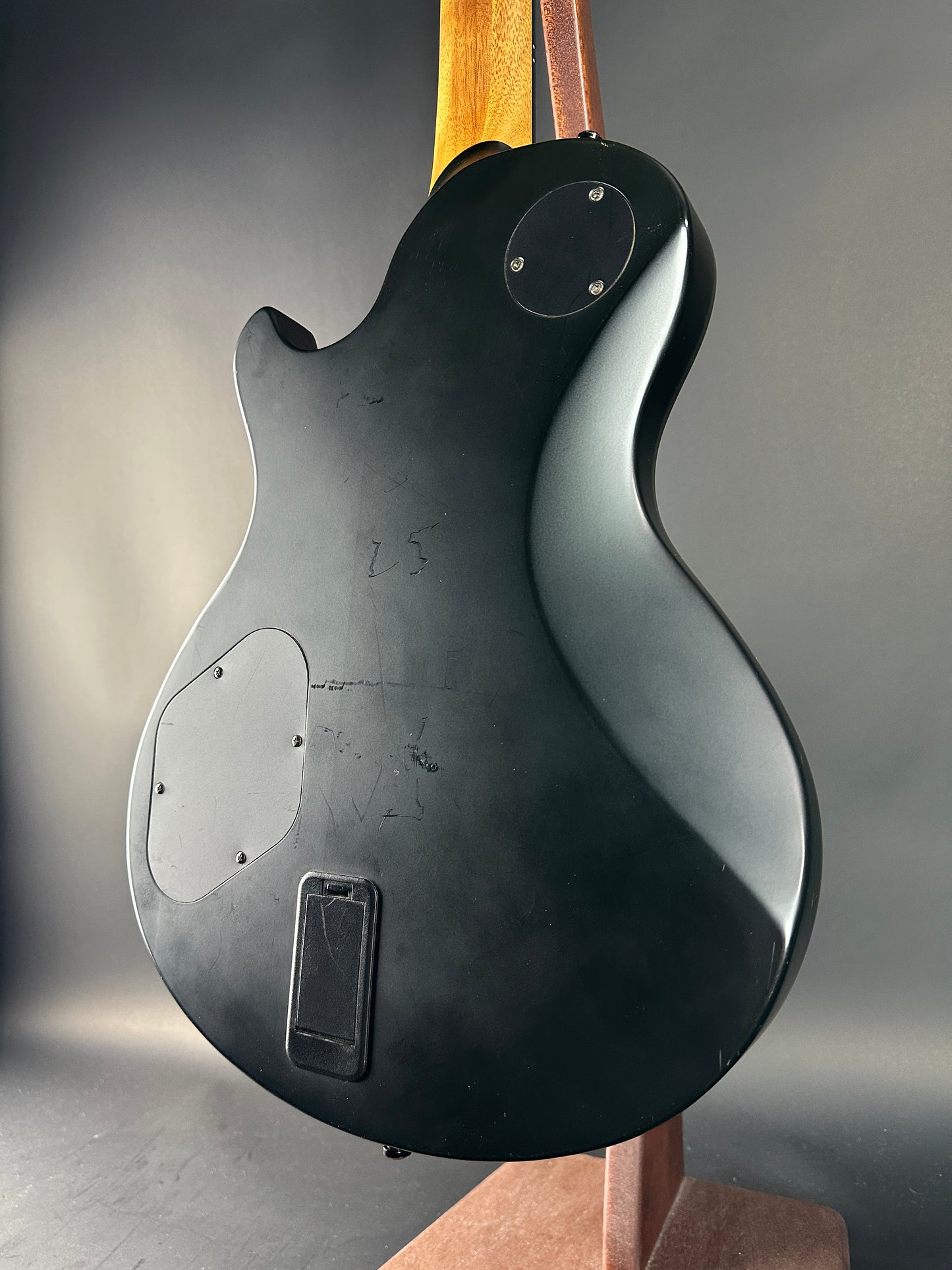 Close-up of a guitar's back with a dark gray background