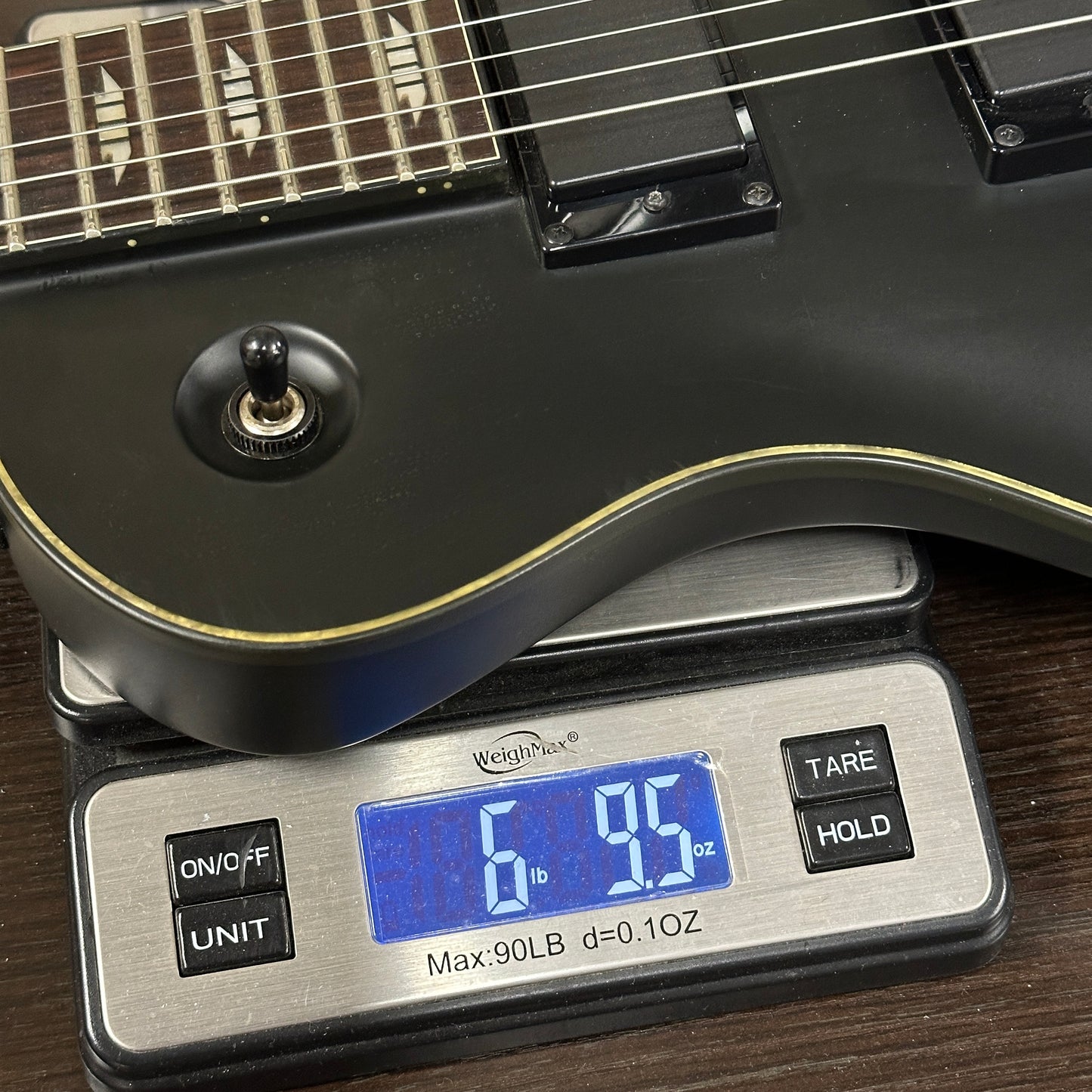 Guitar on a digital scale displaying weight