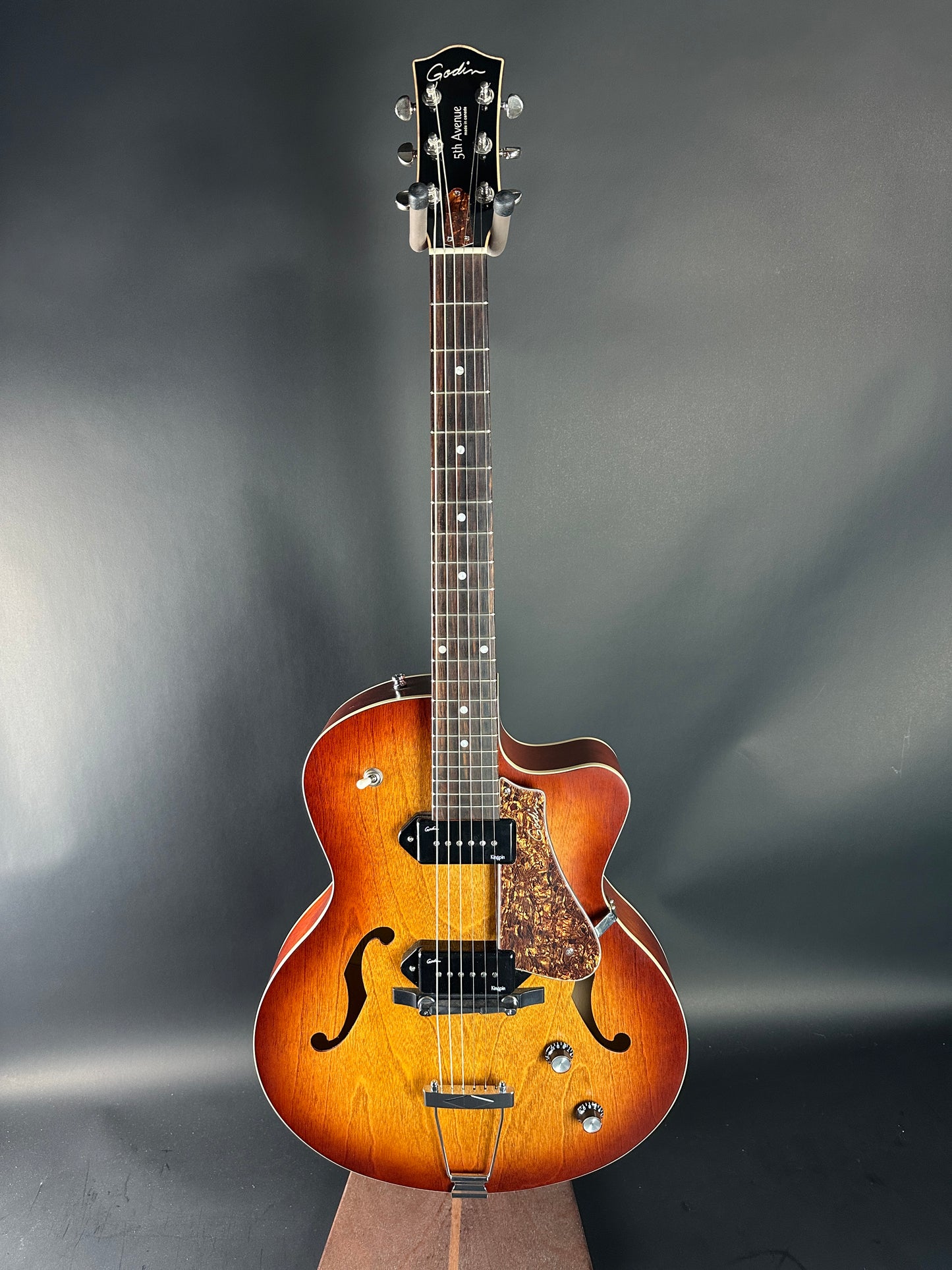 Acoustic guitar with a wooden finish on a dark gray background