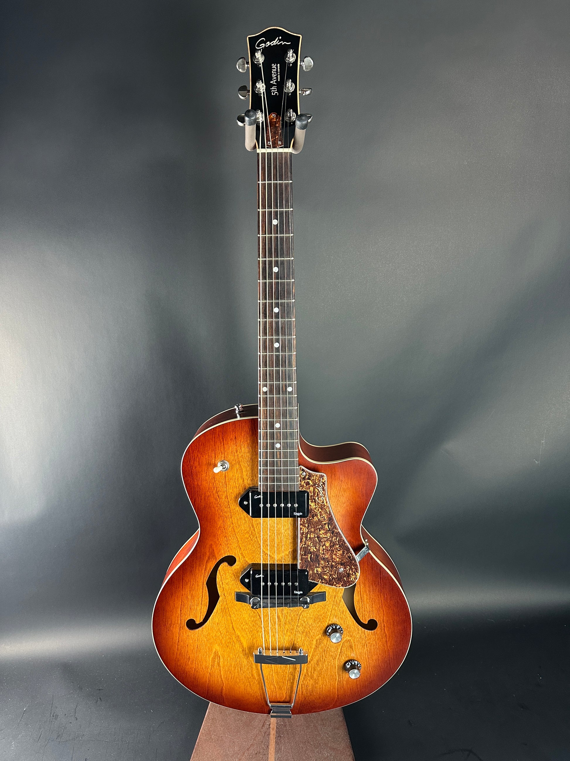 Acoustic guitar with a wooden finish on a dark gray background