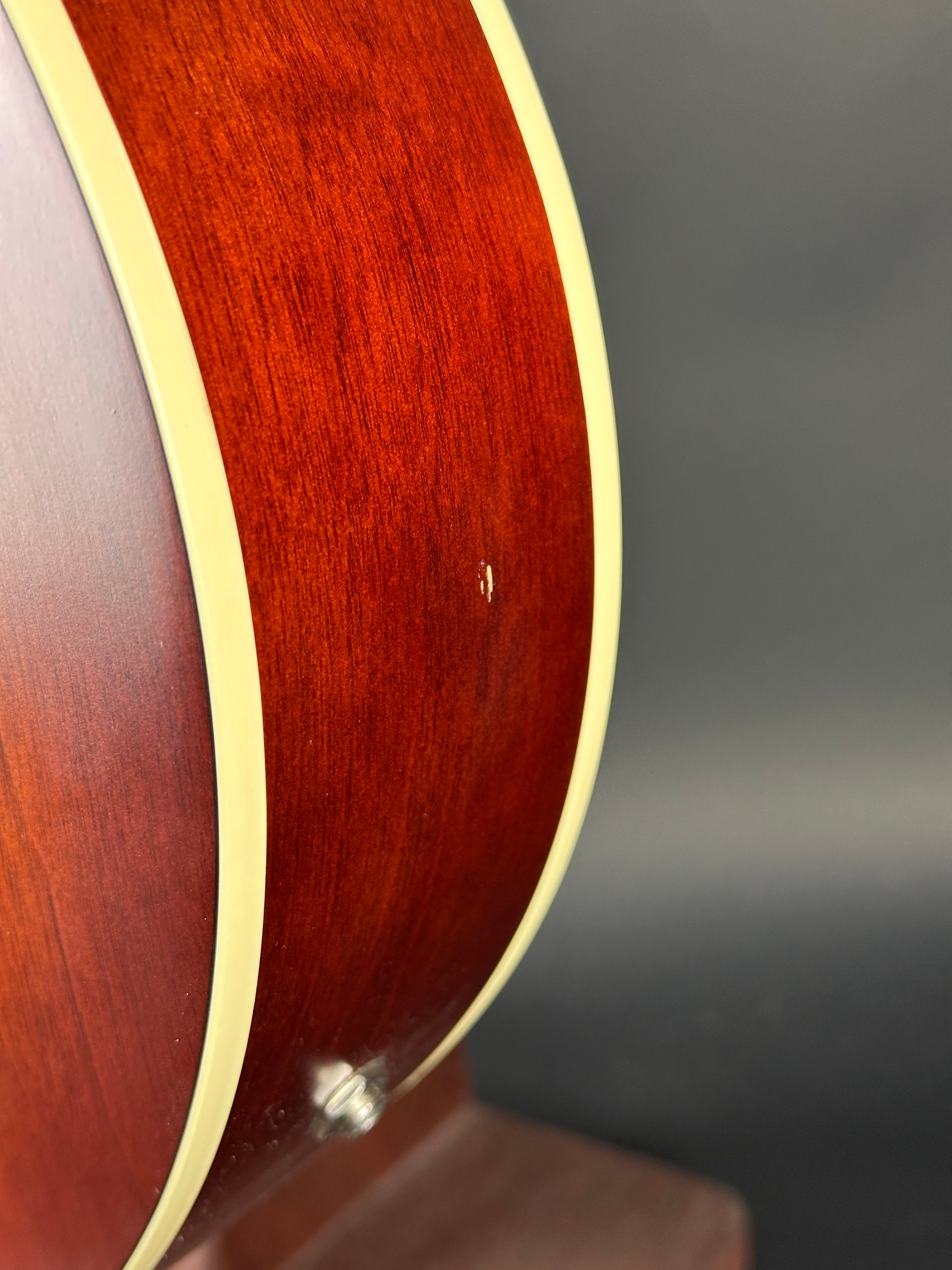 Close-up of a guitar's wooden neck with a dark gray background