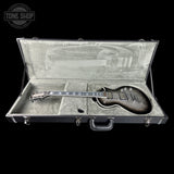 Electric guitar in an open hard-shell case with 'Tone Shop' logo.