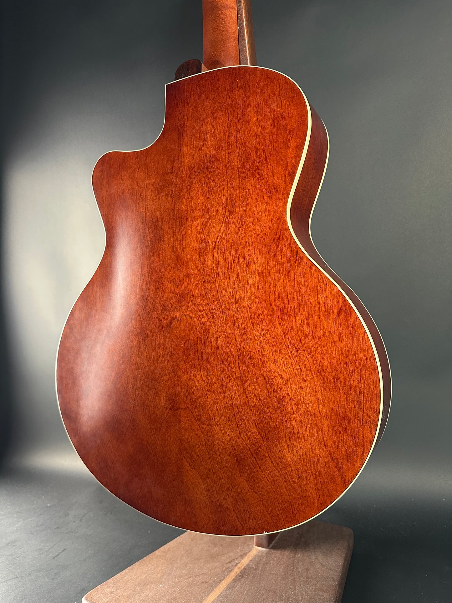 Close-up of a wooden acoustic guitar on a dark background