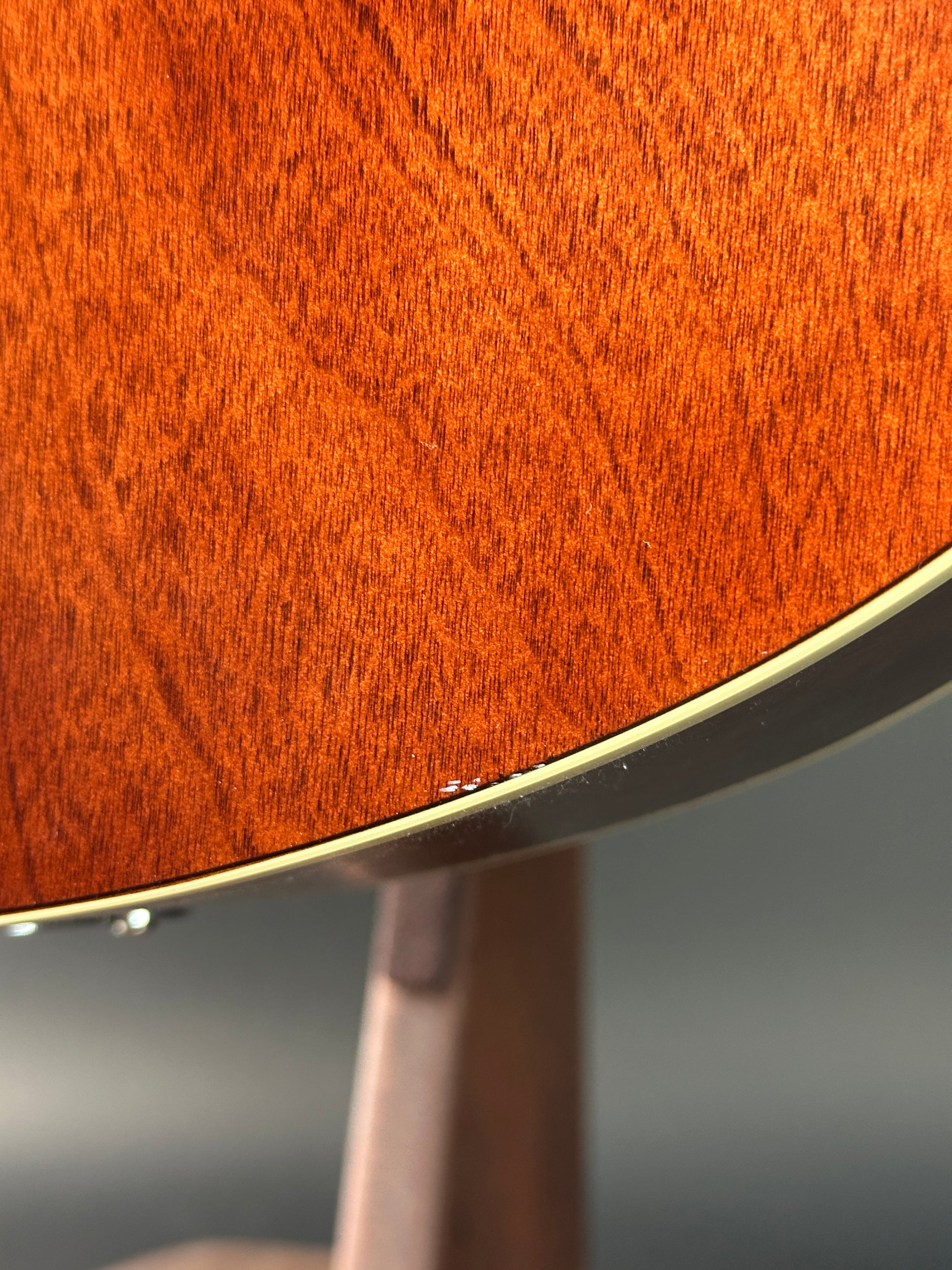 Close-up of a wooden guitar with a metallic finish on a blurred background