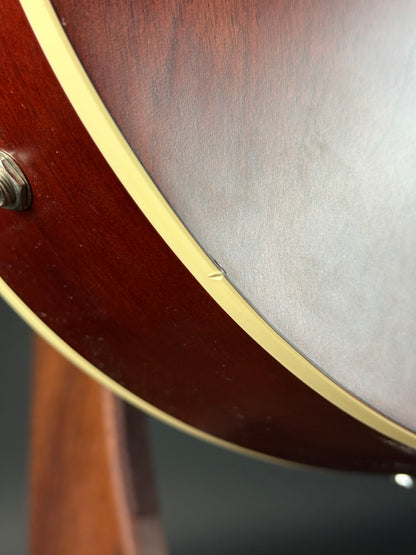 Close-up of a banjo's wooden body with a metallic rim.