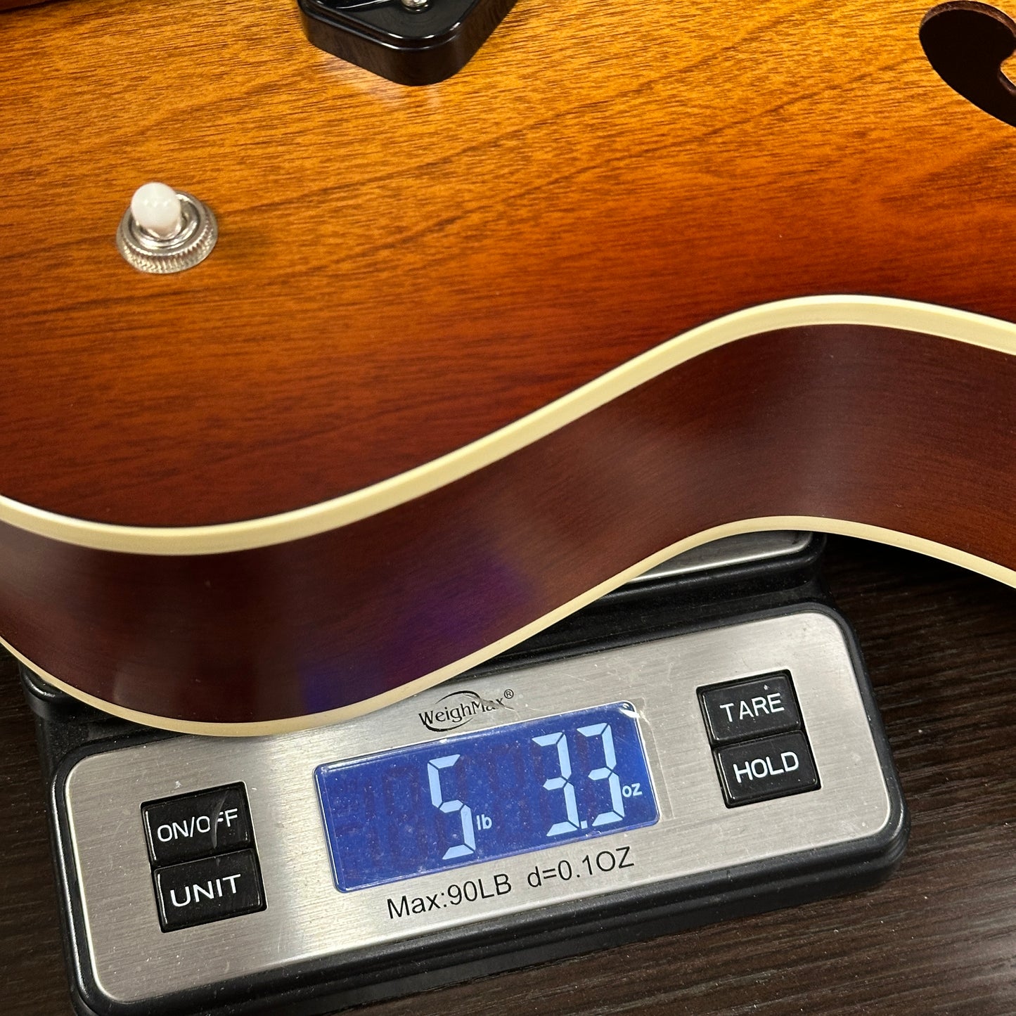 Used Godin 5th Avenue Kingpin II P90 Cognac Burst on a scale displaying weight.