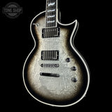 Silver electric guitar with a textured finish on a black background, featuring the Tone Shop logo.