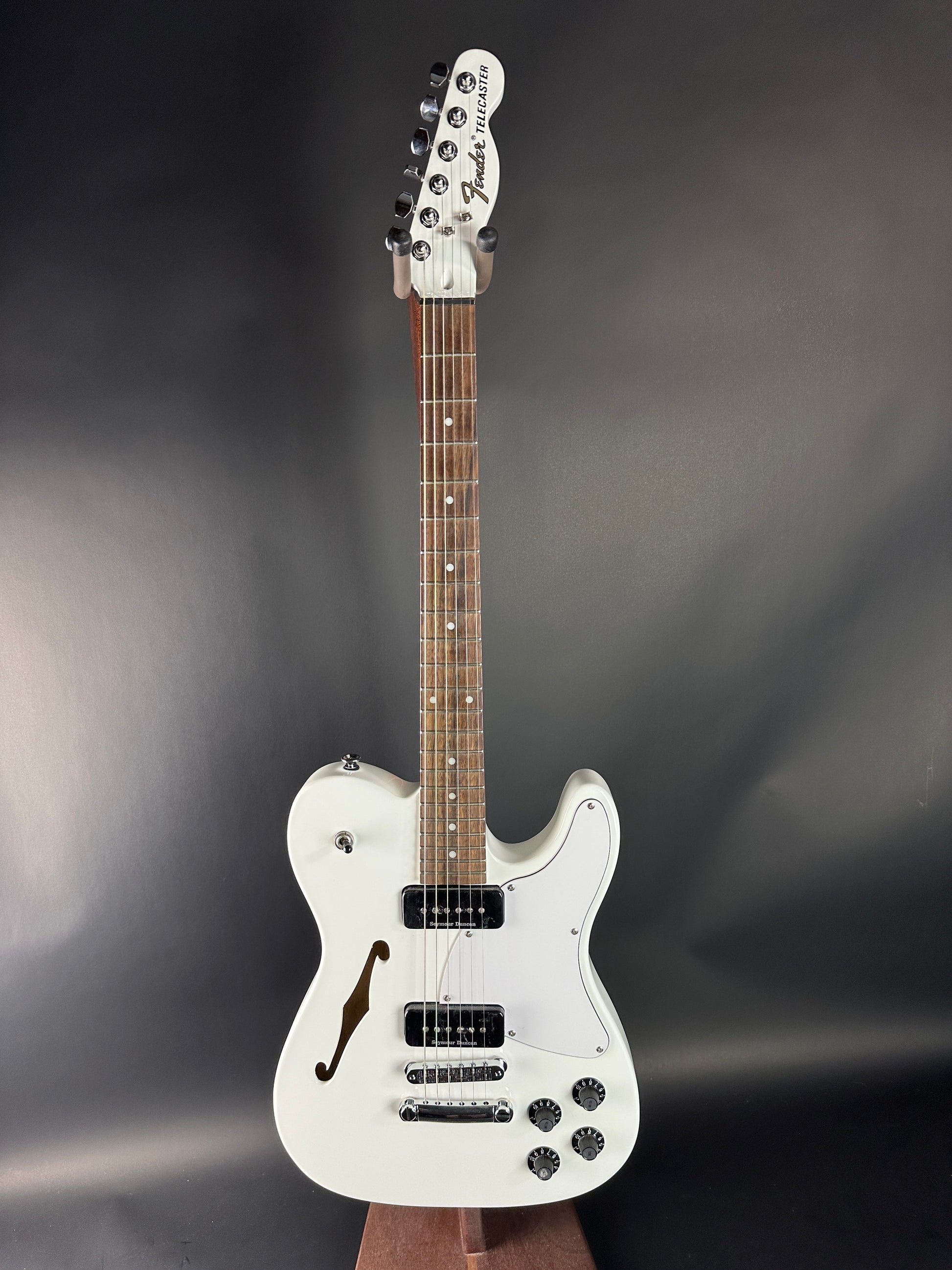 White electric guitar on a dark gray background