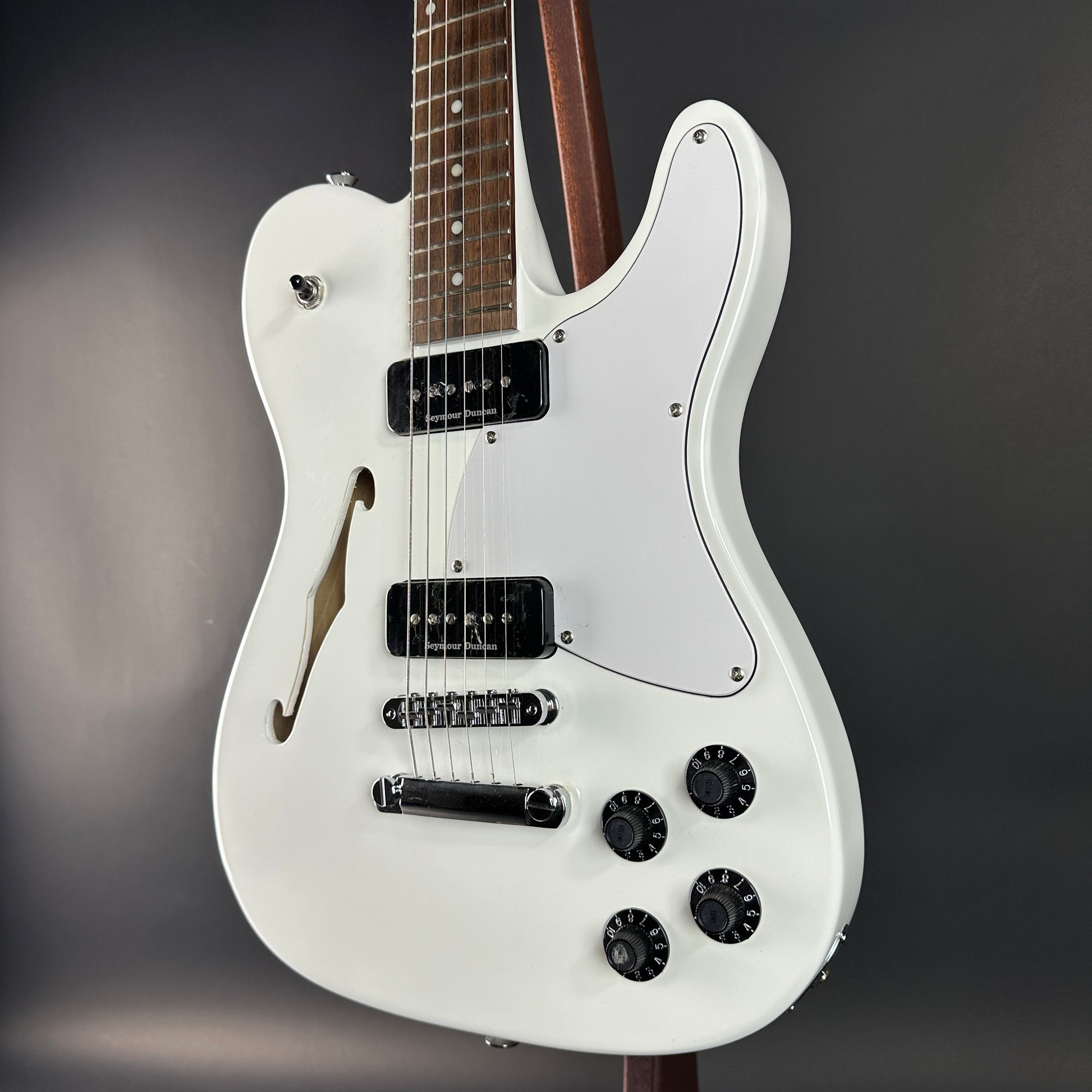 White electric guitar on a dark gray background