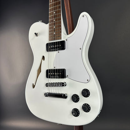 White electric guitar on a dark gray background