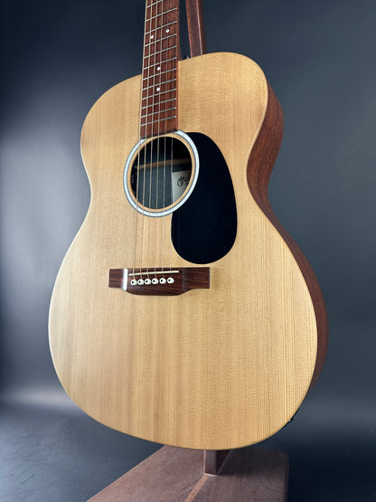 Acoustic guitar with a visible brand logo on a dark background