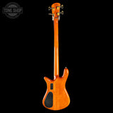 The back view of an electric bass guitar with a glossy orange cherry finish, shown against a solid black background. A Tone Shop watermark is visible in the top-left corner.