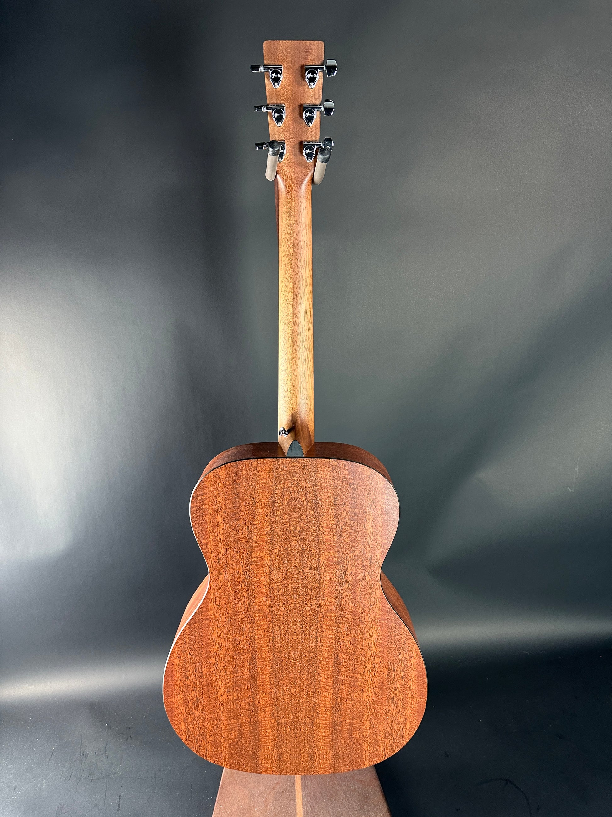 Wooden acoustic guitar on a dark gray background