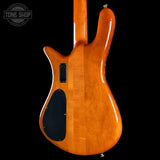 The back of a modern electric guitar with a glossy orange-brown cherry finish, featuring a cutaway body shape, black pickups, and a black pickguard, shown against a solid black background.