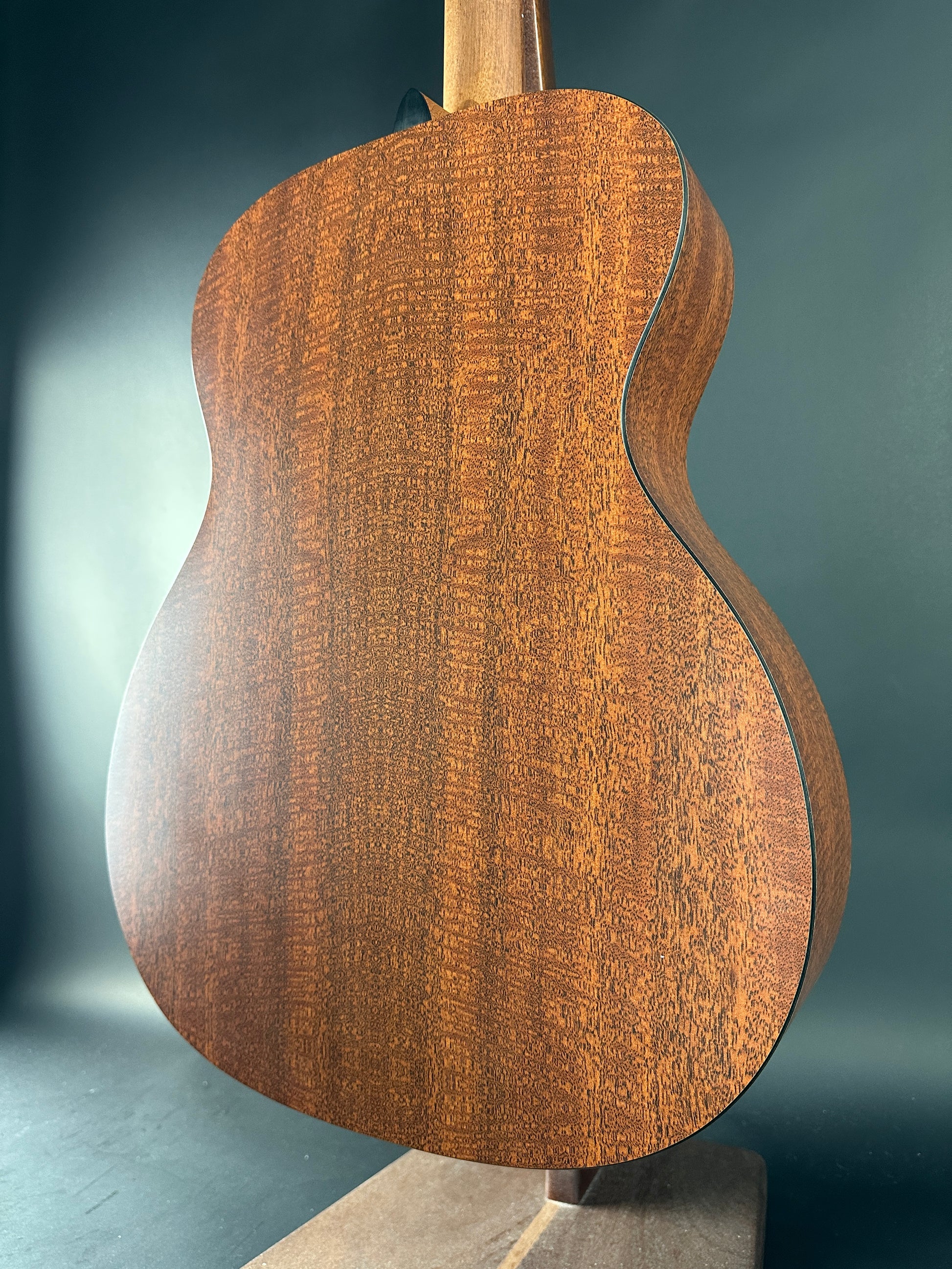 Close-up of a wooden guitar body on a dark background