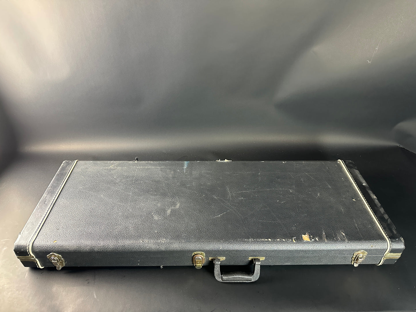 Black rectangular case with visible wear on a dark background