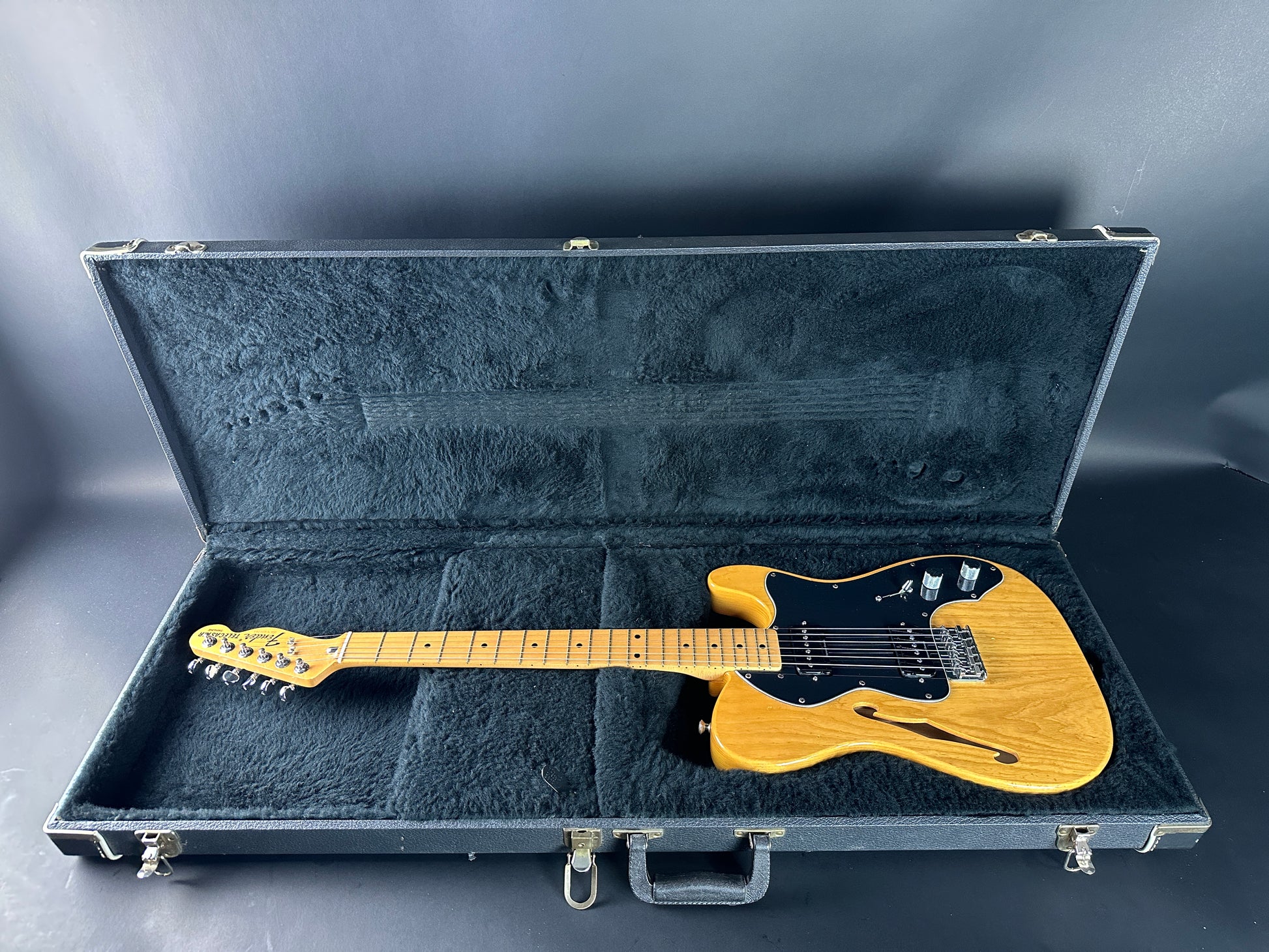 Electric guitar in a hard-shell case on a gray background