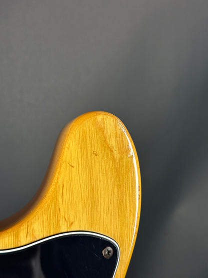 Close-up of a guitar's wooden neck and headstock on a dark background