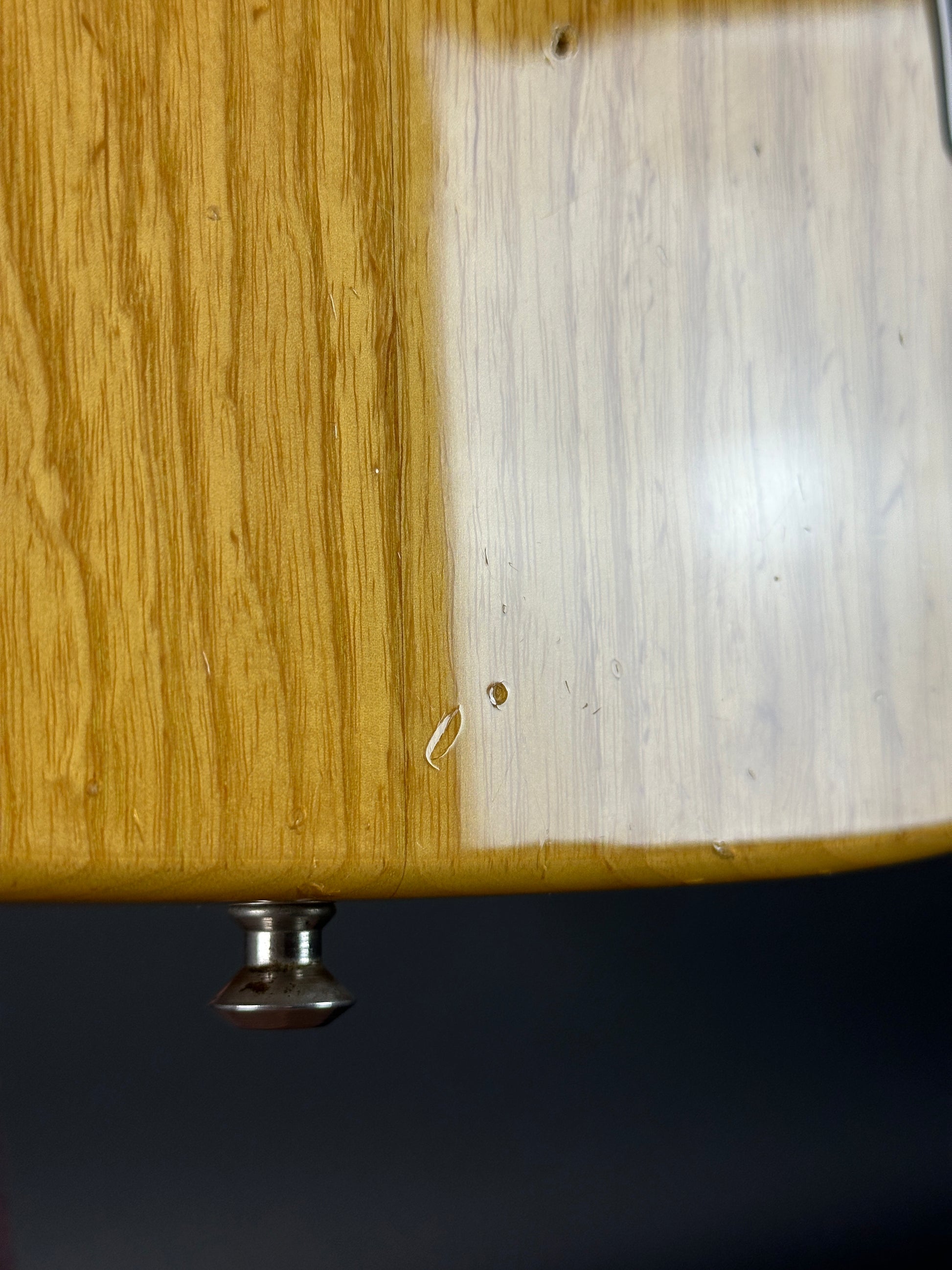 Wooden surface with a metal knob on a dark background