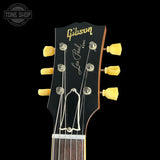 Gibson Les Paul guitar headstock with yellow tuning pegs on a black background