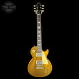Gold electric guitar on a black background with 'Tone Shop' logo.