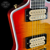 Close-up of a red and yellow electric guitar with a visible brand logo.