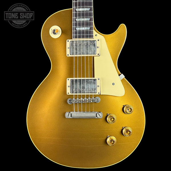 Gold electric guitar with a 'Tone Shop' logo in the corner