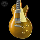Gold electric guitar on a black background with 'Tone Shop' logo.