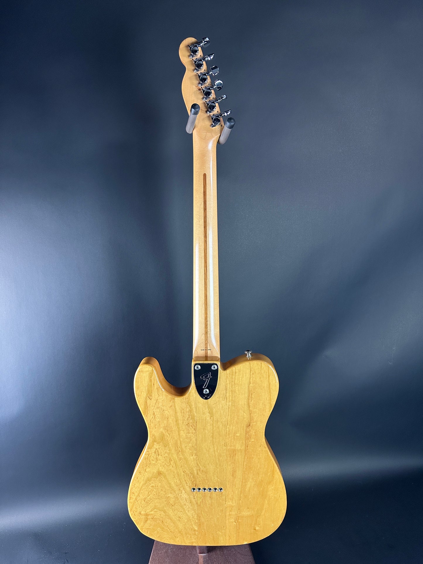 Electric guitar with a wooden body and neck on a dark blue background