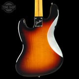 Close-up of the back of a Fender Stratocaster electric guitar showing a classic 3-color sunburst finish that transitions from bright amber-orange to dark brown, with a black pickguard and maple neck visible against a black background.