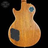 Back view of a wooden guitar with a visible brand logo on a black background