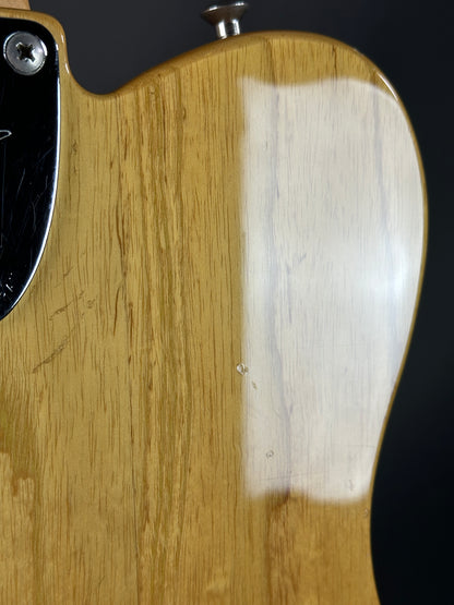 Close-up of a guitar's wooden body with a visible scratch.