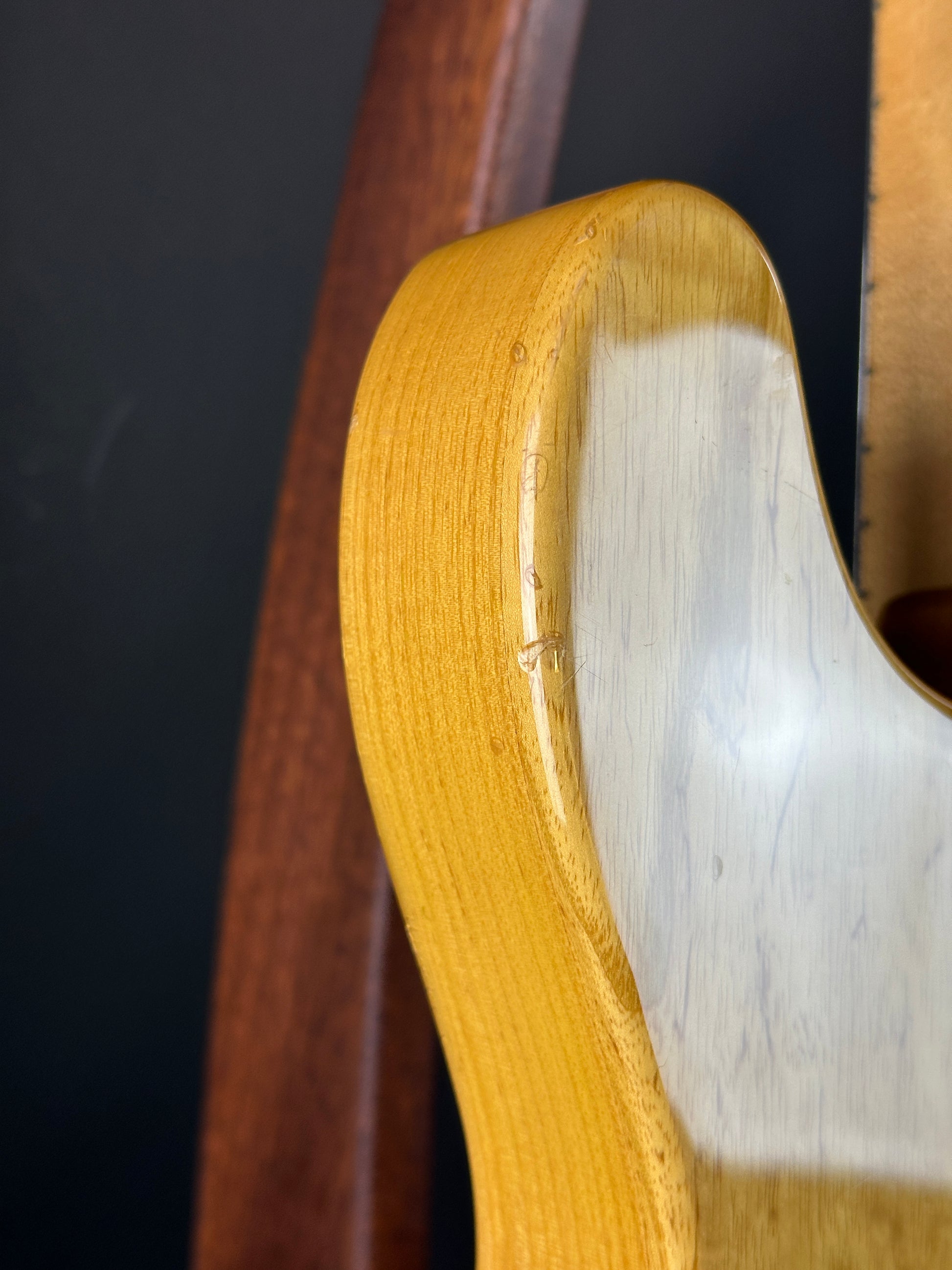 Close-up of a wooden chair armrest on a black background