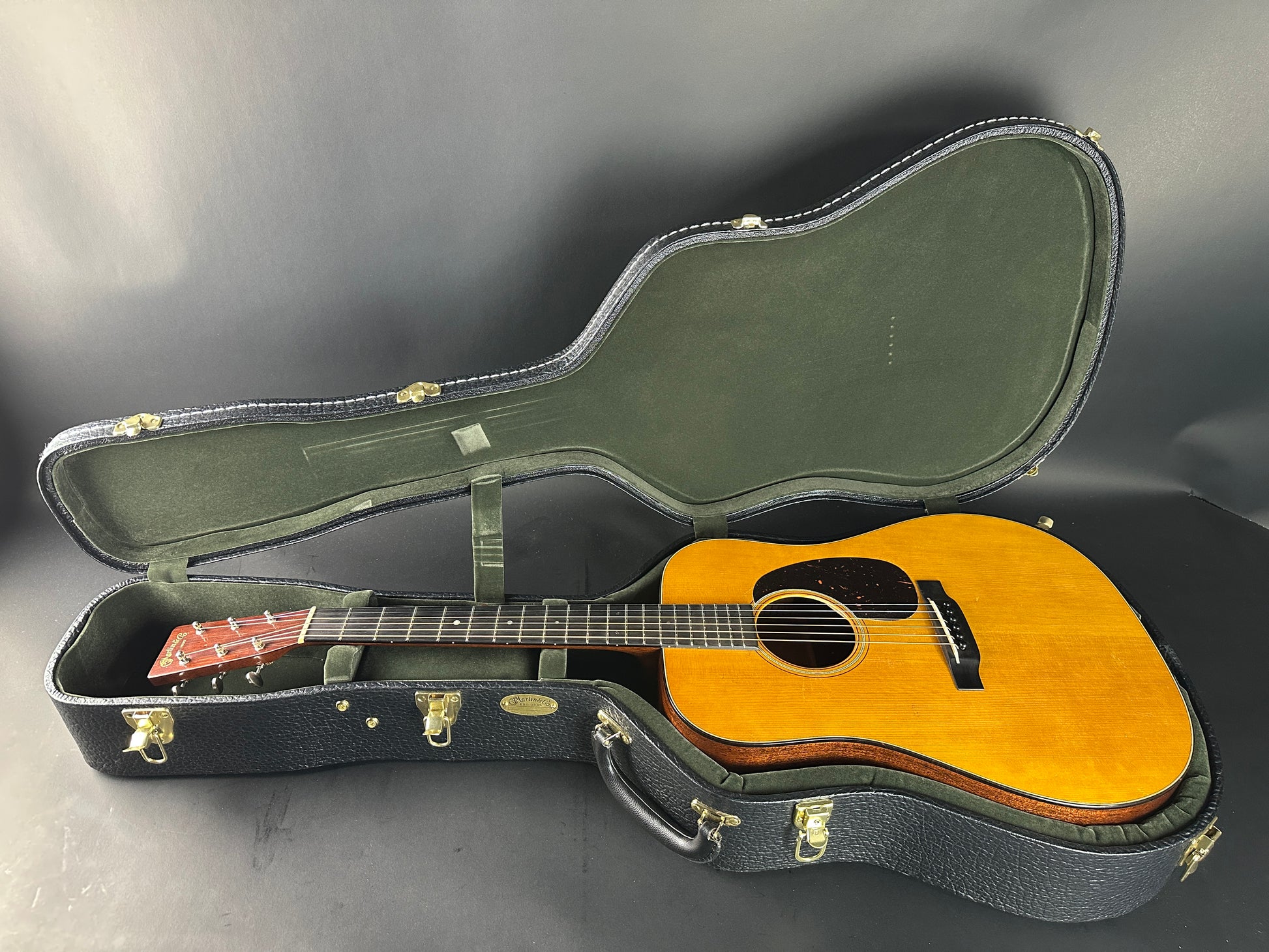 Acoustic guitar in a case on a gray background
