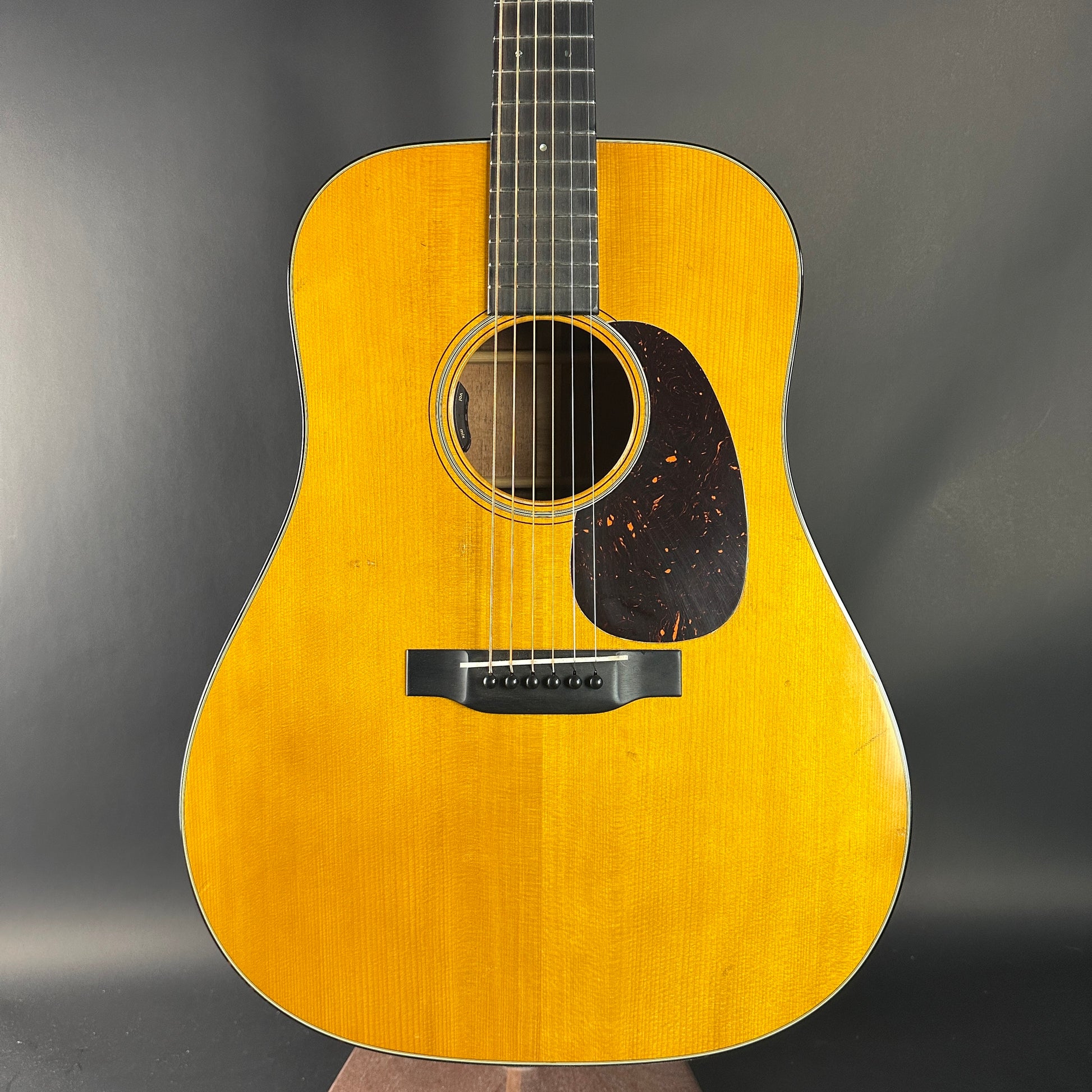 Acoustic guitar with a wooden finish on a dark background