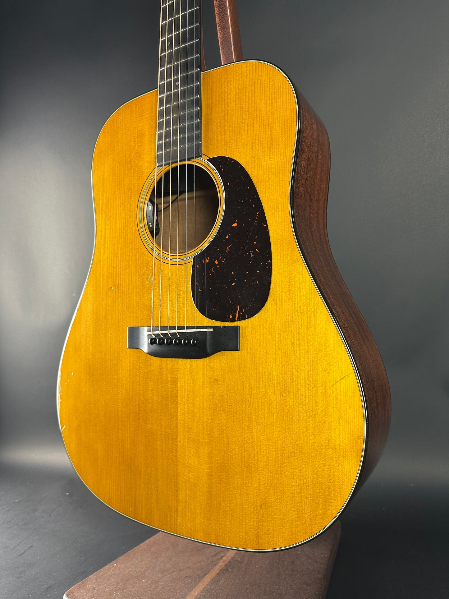 Acoustic guitar with a wooden finish on a dark background