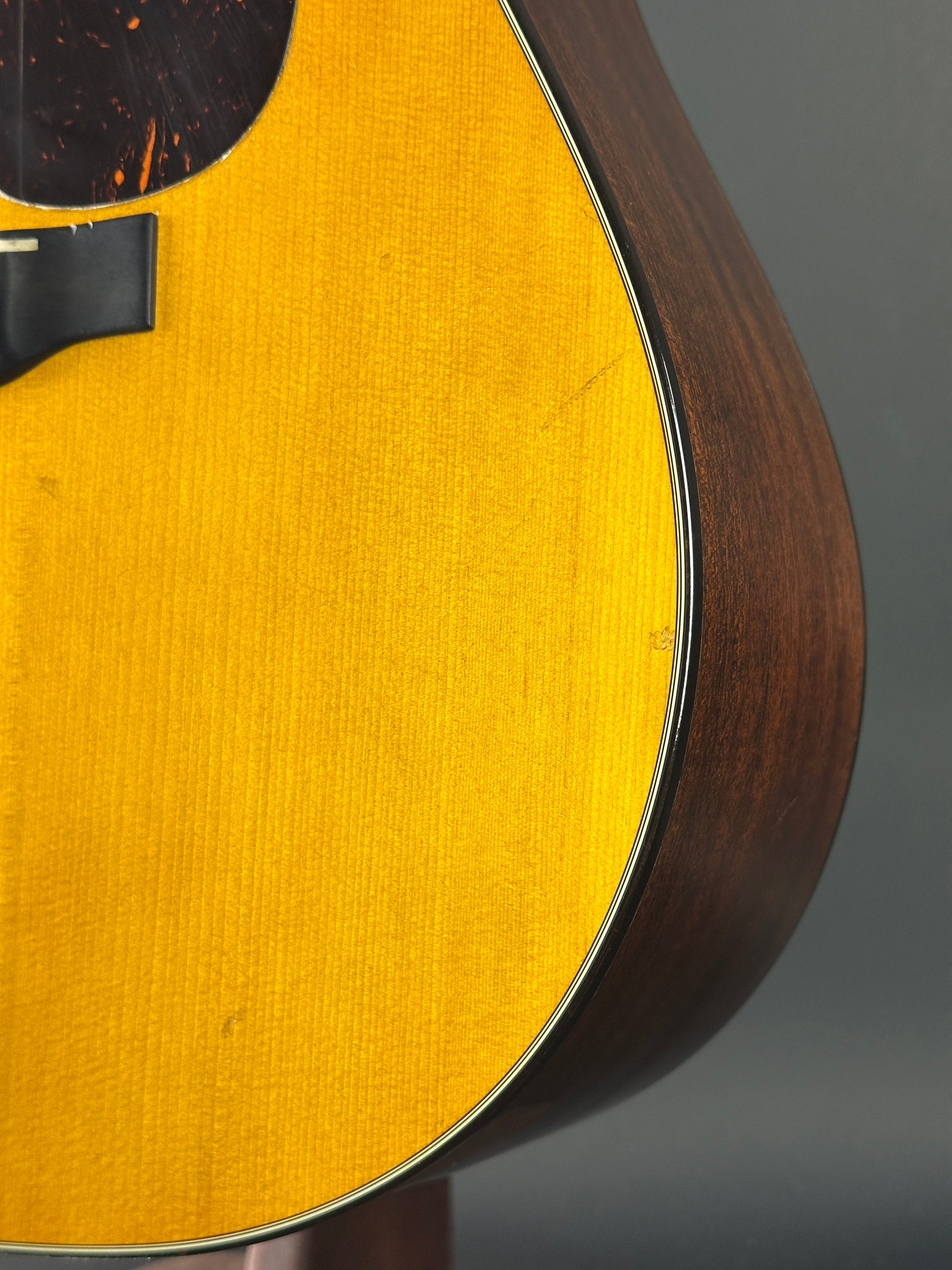 Close-up of a guitar's soundhole with a wooden rim and yellow soundboard.