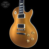 A gold metallic electric guitar with chrome hardware, shown from a front three-quarter angle against a solid black background. A Tone Shop watermark is visible in the top-left corner.