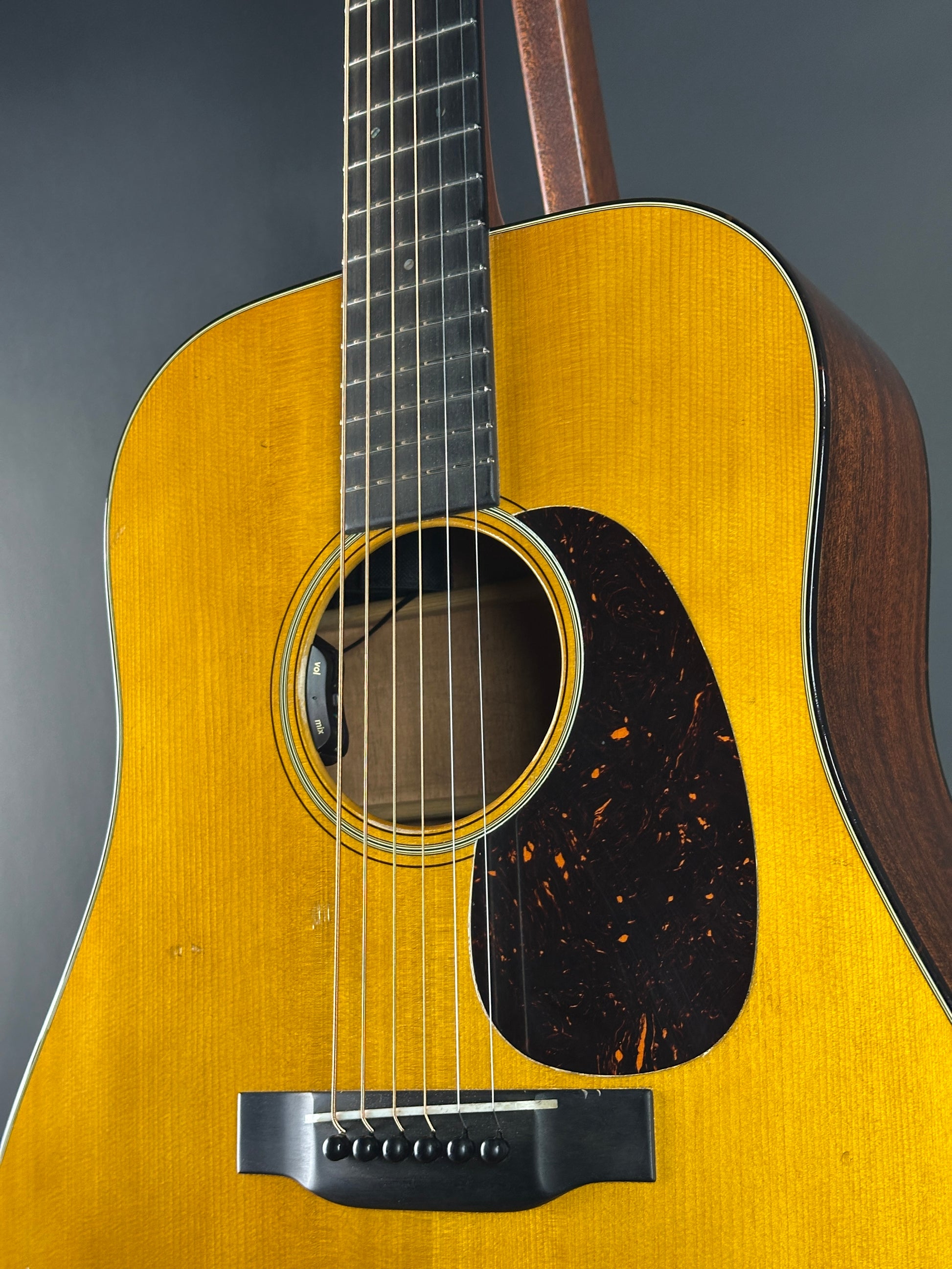 Close-up of a yellow acoustic guitar on a gray background