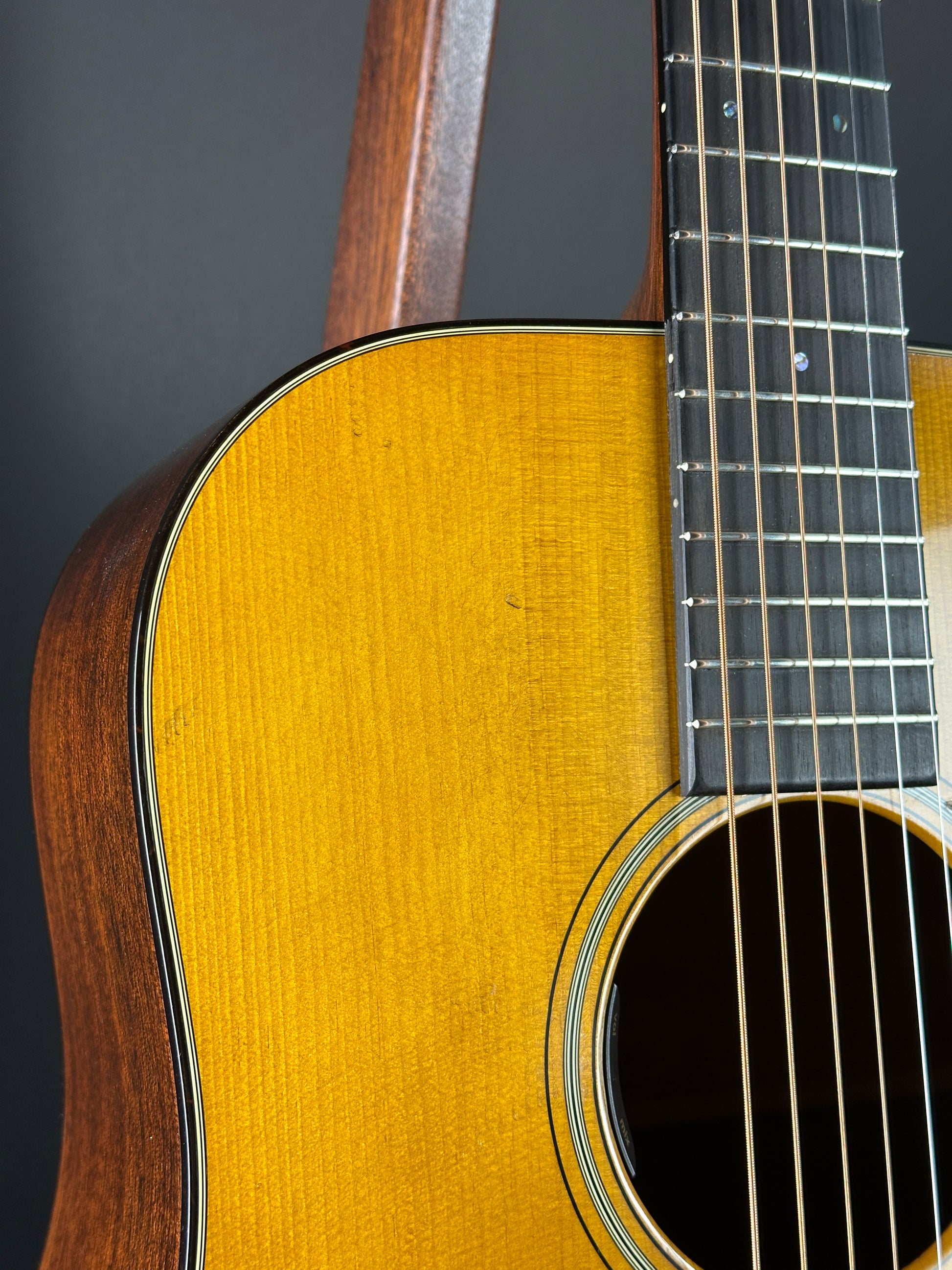 Close-up of a yellow acoustic guitar with a dark background