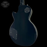 The rear view of a glossy black electric guitar against a solid black background, showing the back body, pickups, and a Tone Shop watermark in the upper left corner.