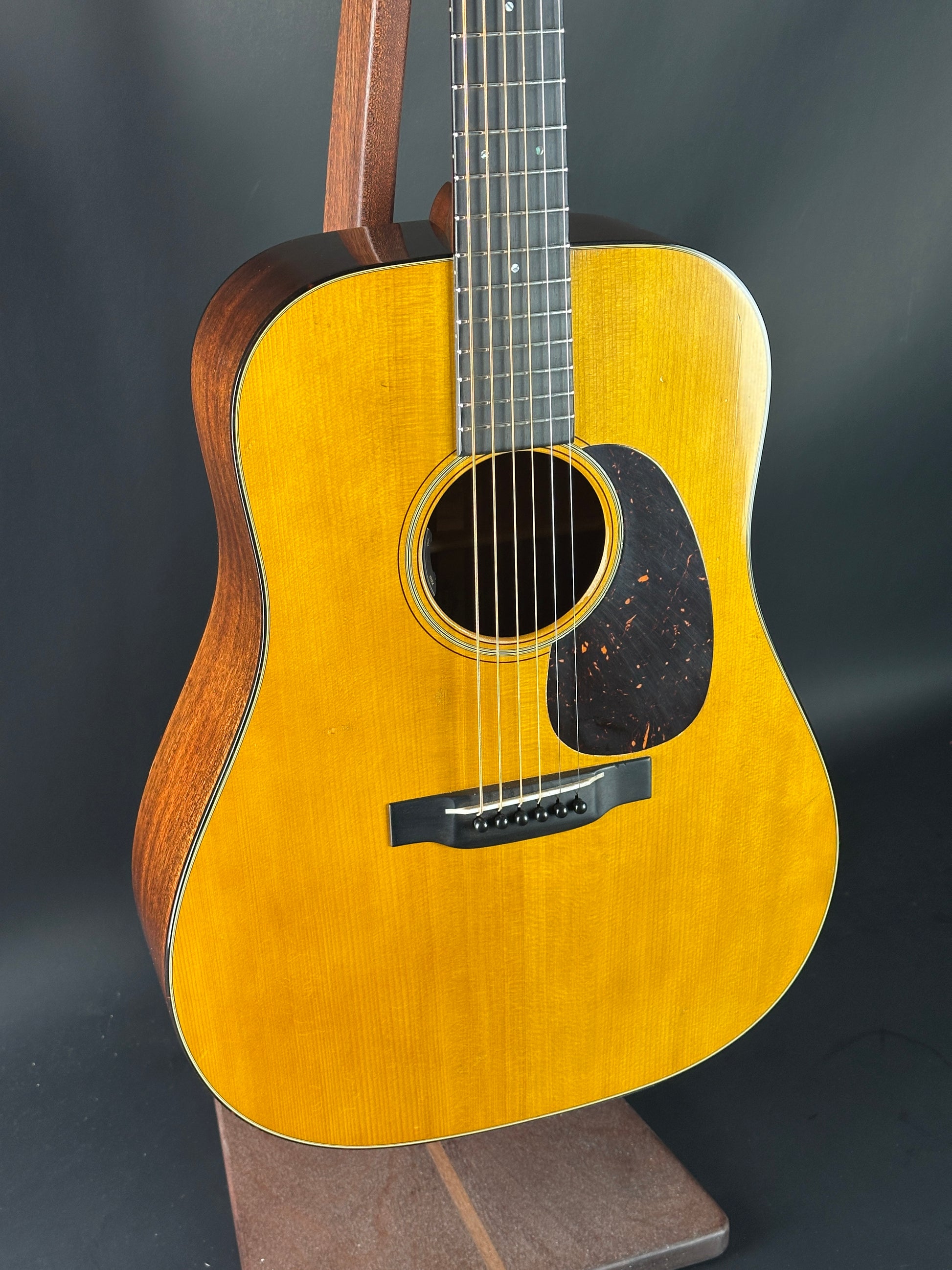 Acoustic guitar with a wooden finish on a dark background